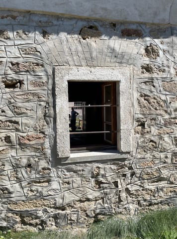 Geöffnetes Fenster in Fassade mit Steinimitation-Putz