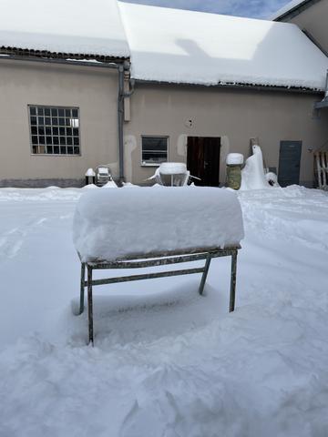 Verschneite Terrasse mit Tisch und Stühlen