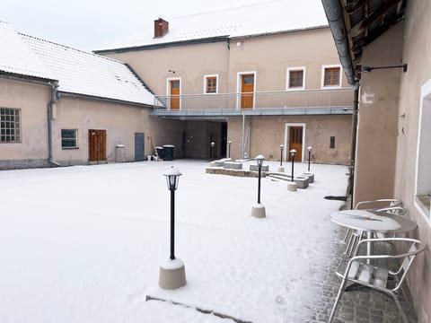 Verschneiter Innenhof mit Laternen im Winter