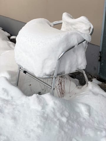 Schneebedeckter Stuhl im tiefen Schnee