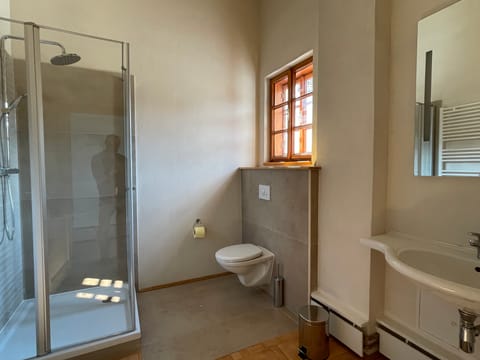 Badezimmer mit Waschbecken, WC und Duschkabine
